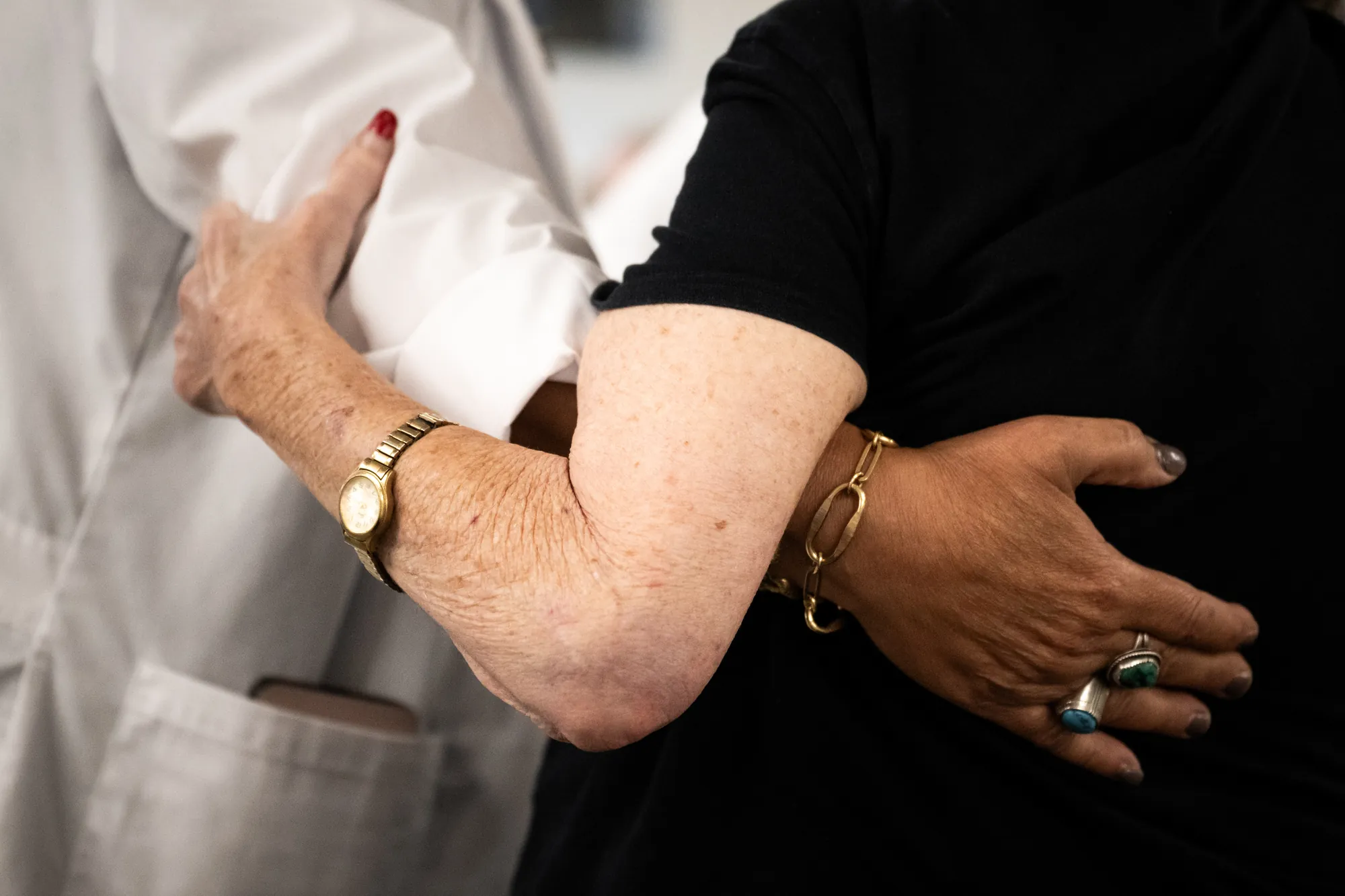 A clinician's hand resting on a resident's forearm at Amara