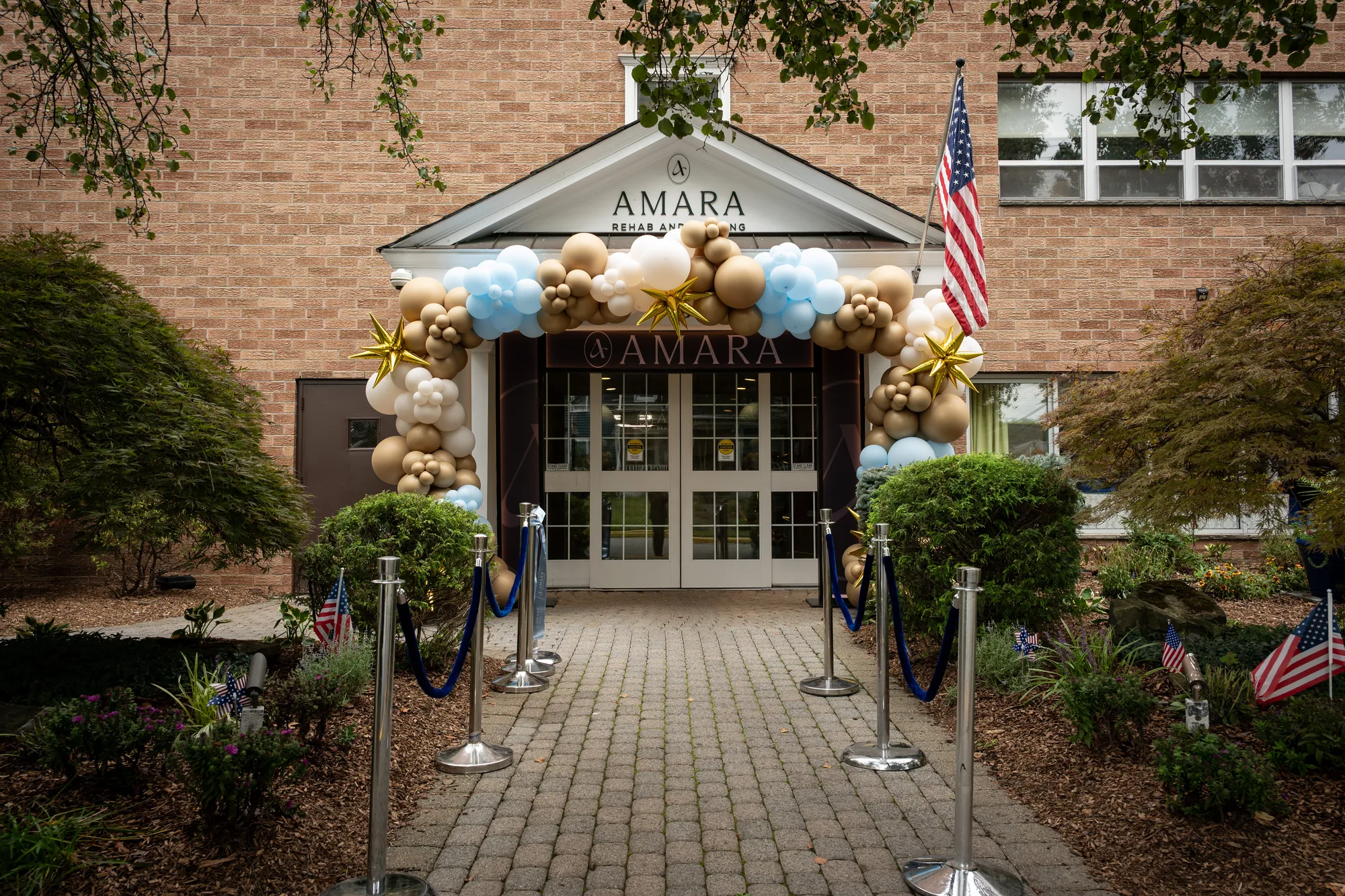 The Amara entrance dressed for the open house with a balloon arch and florals at dusk