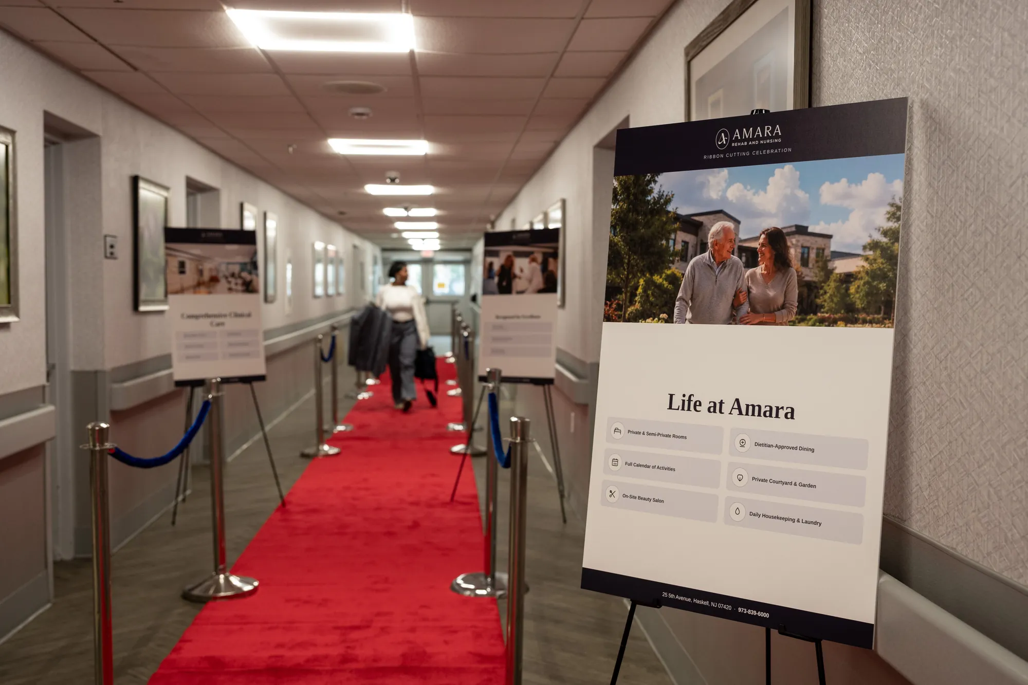 A framed Life at Amara print displayed on an easel beside the red carpet