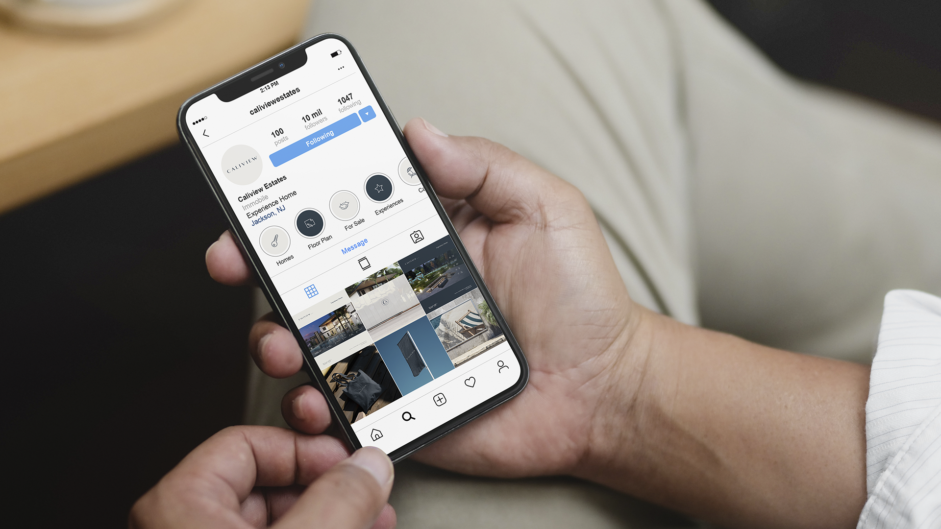 Hand holding a phone showing the Caliview Estates Instagram profile