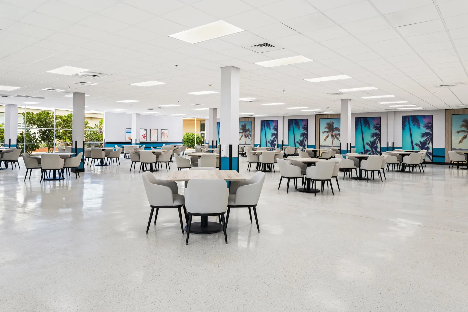 Carlton Shores dining hall with palm tree wall art and seated cafe layout