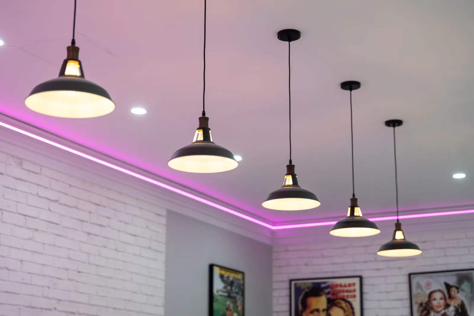 Industrial pendant lights with magenta led accent strip in the bistro ceiling