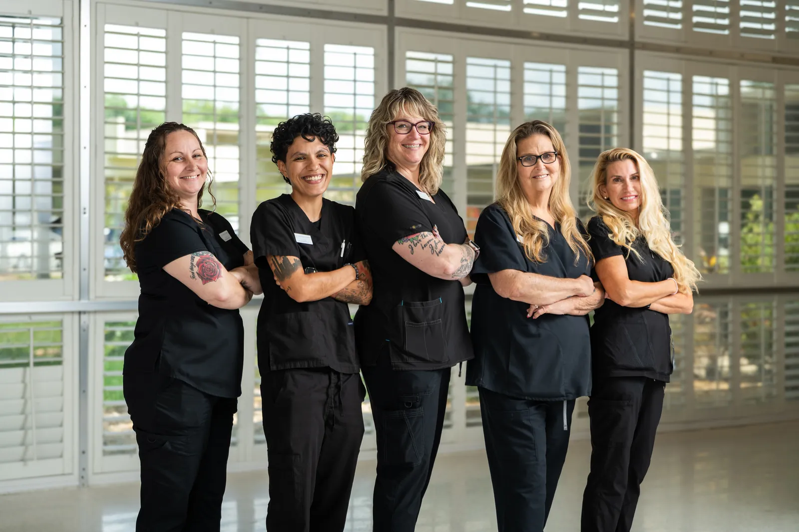 Five Carlton Shores nursing staff in black scrubs, arms crossed