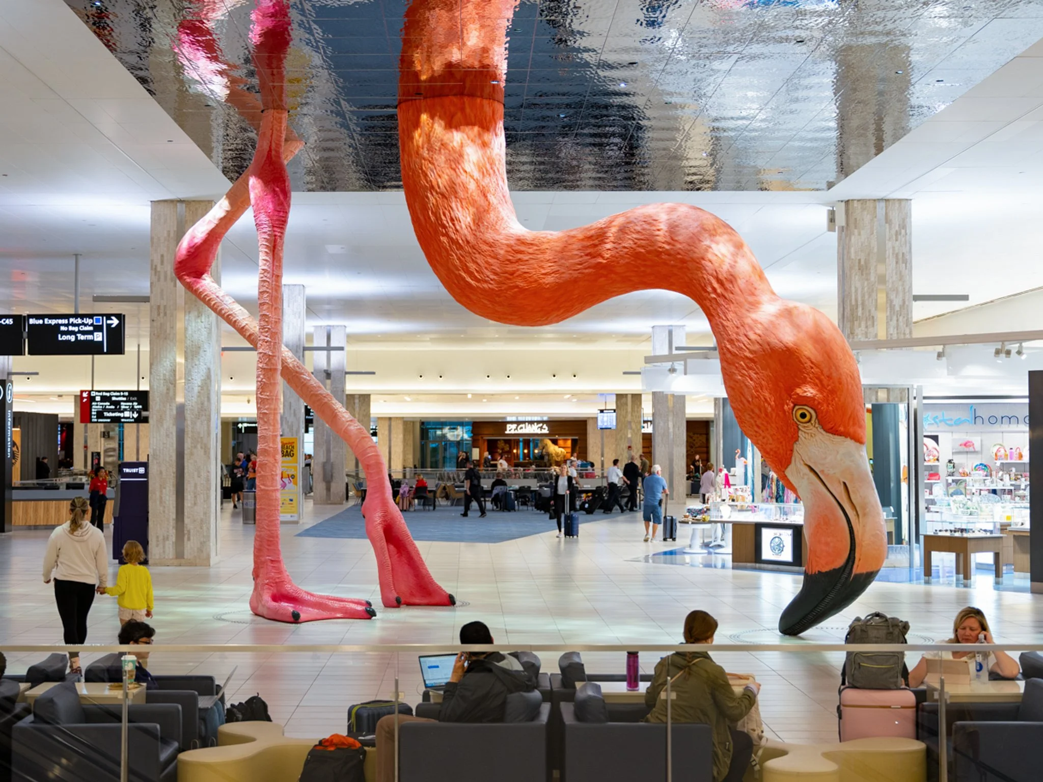 Travelers with flamingo installation, Tampa Airport
