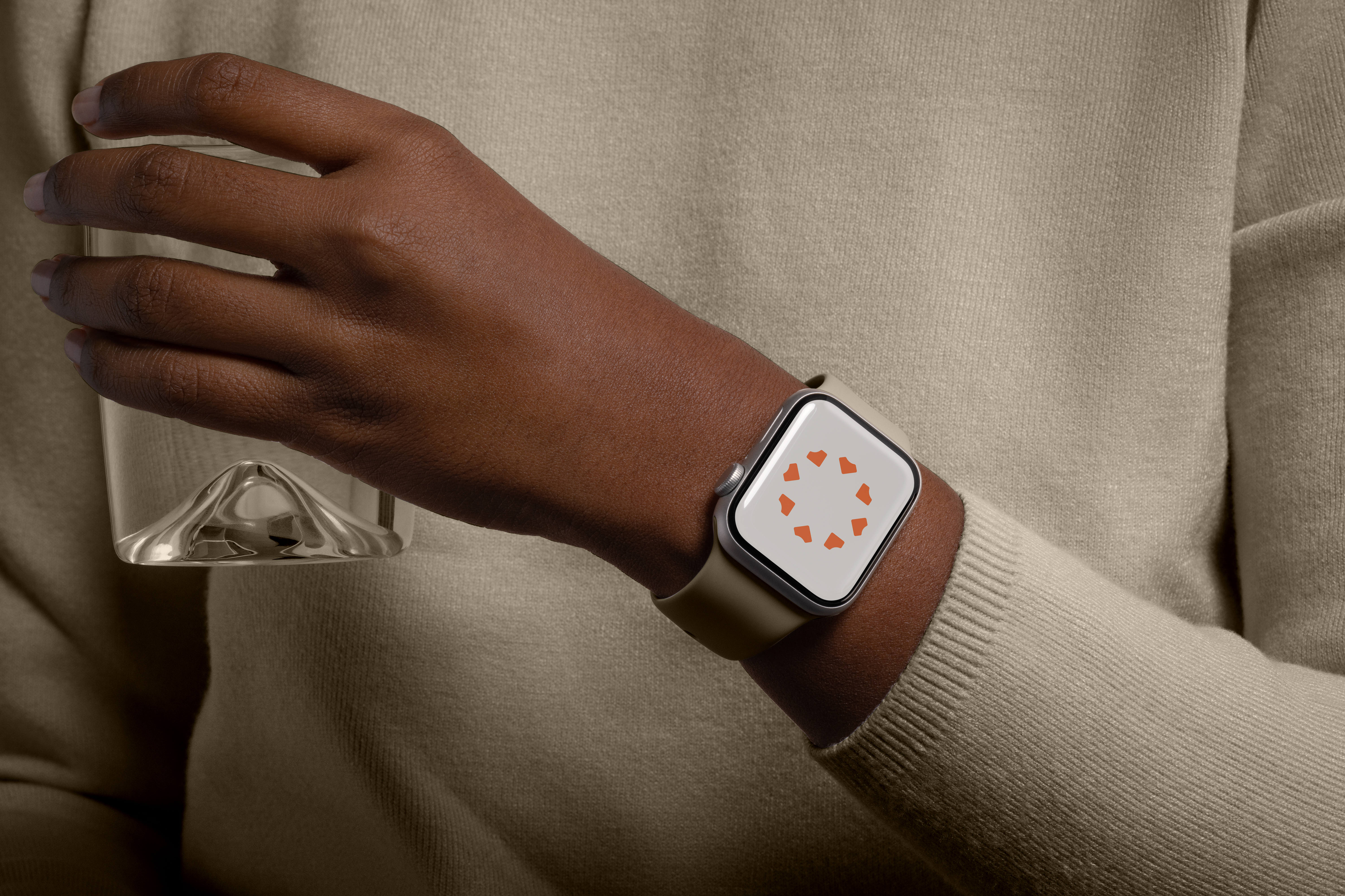 Smartwatch on a wrist showing the orange Precision dot mark on its face