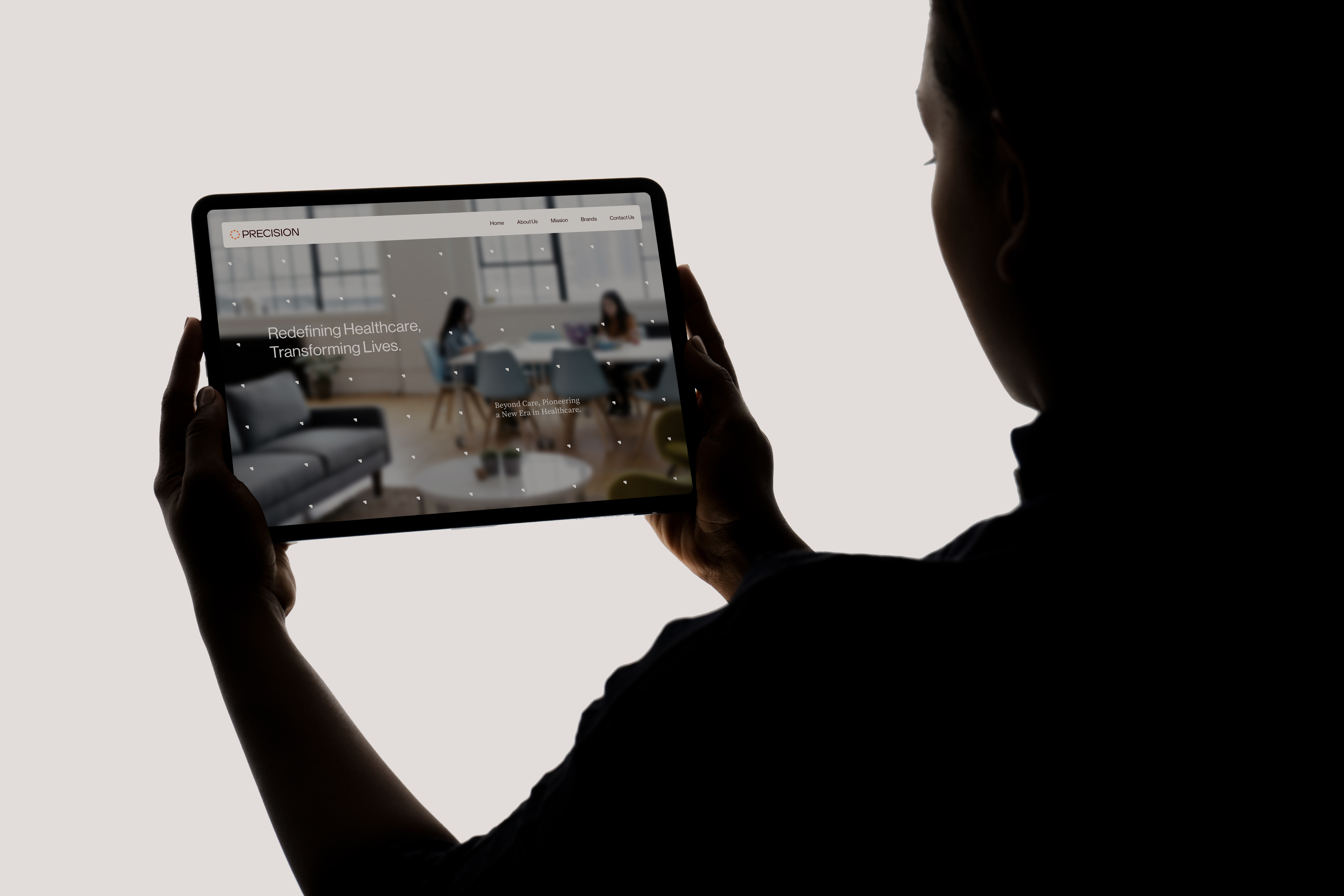 Person holding a tablet showing the Precision website headline Redefining Healthcare, Transforming Lives