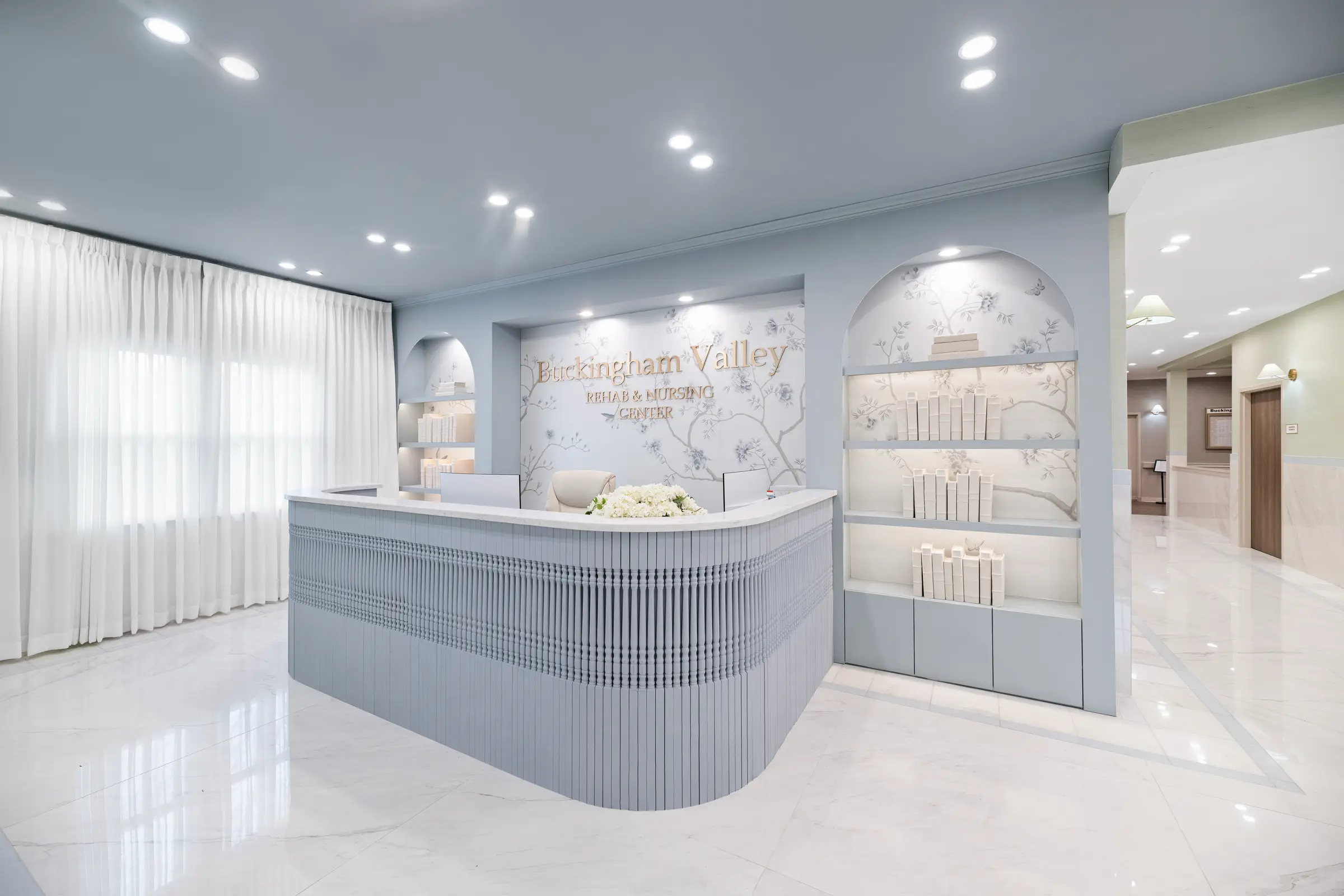 Reception desk styled with fresh white flowers and dressed shelving