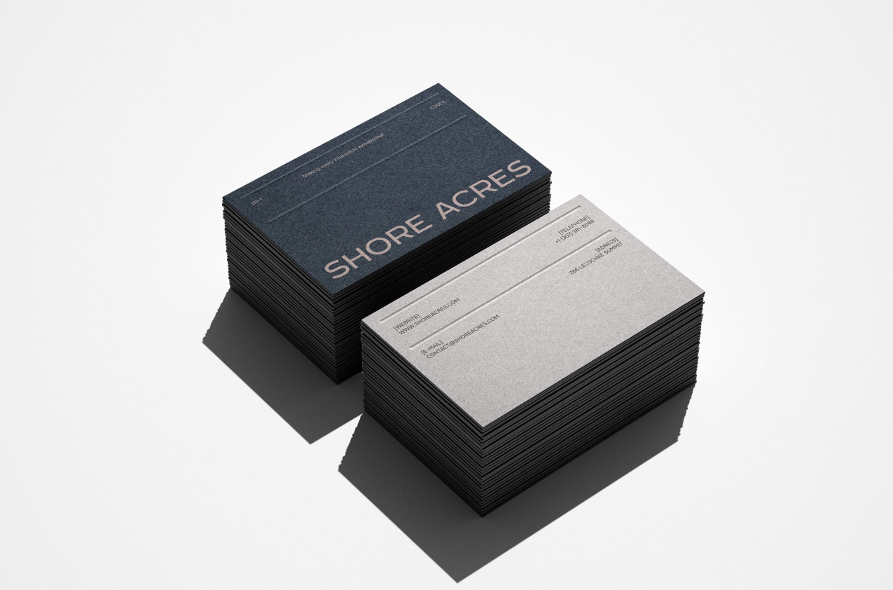 Two stacks of Shore Acres business cards in navy and grey with blush foil type