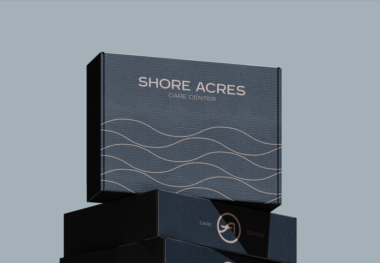 Stacked Shore Acres Care Center gift boxes in navy with the blush wave pattern