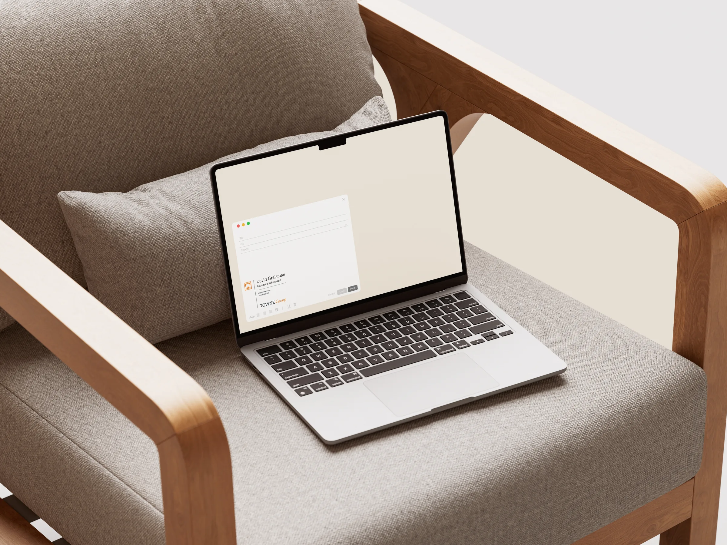 Laptop on an armchair showing an email compose window with the Towne Group signature block