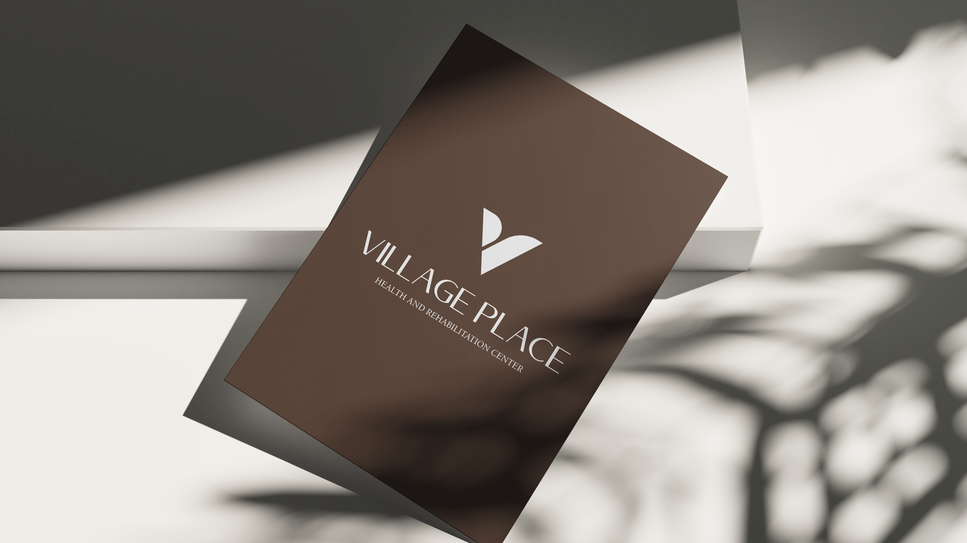 Village Place brochure cover, brown paper with the V mark and serif lockup