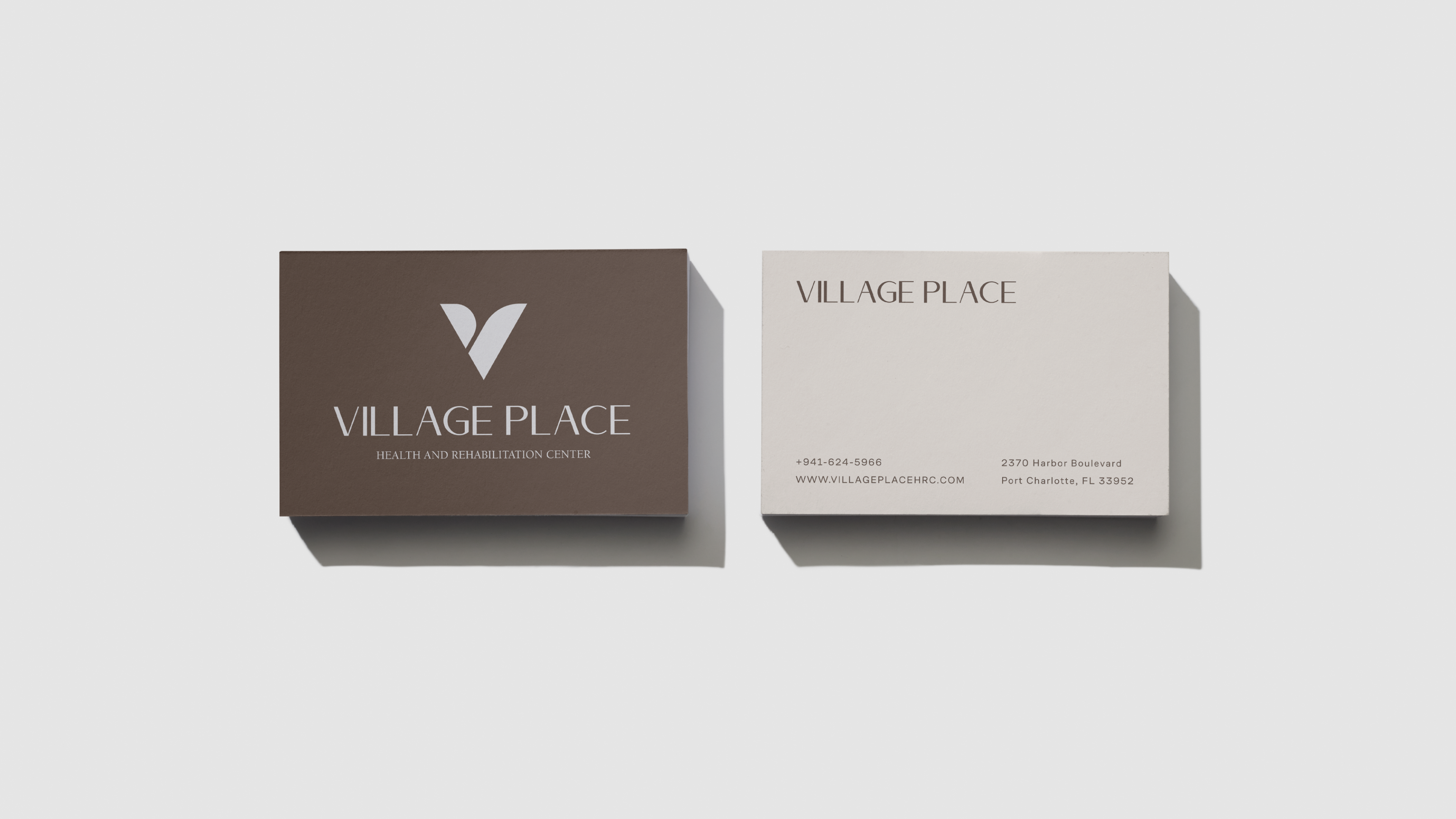 Village Place business cards, brown front with V mark, cream back with contact info