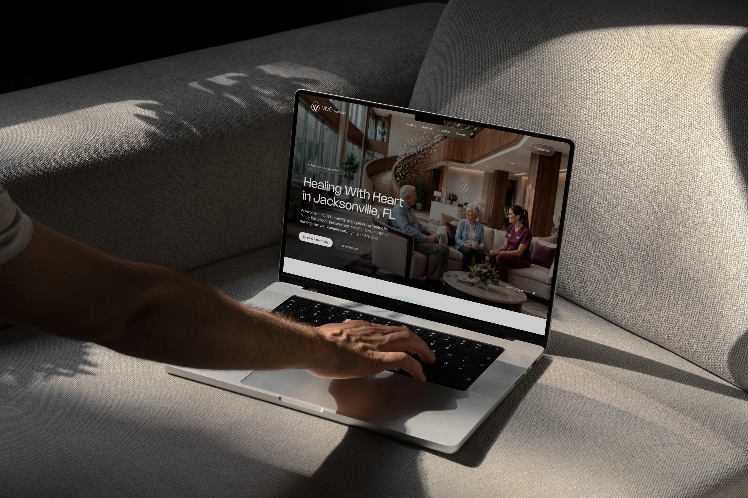 A laptop on a sofa showing the Vivo Healthcare website, with the headline Healing With Heart in Jacksonville, FL