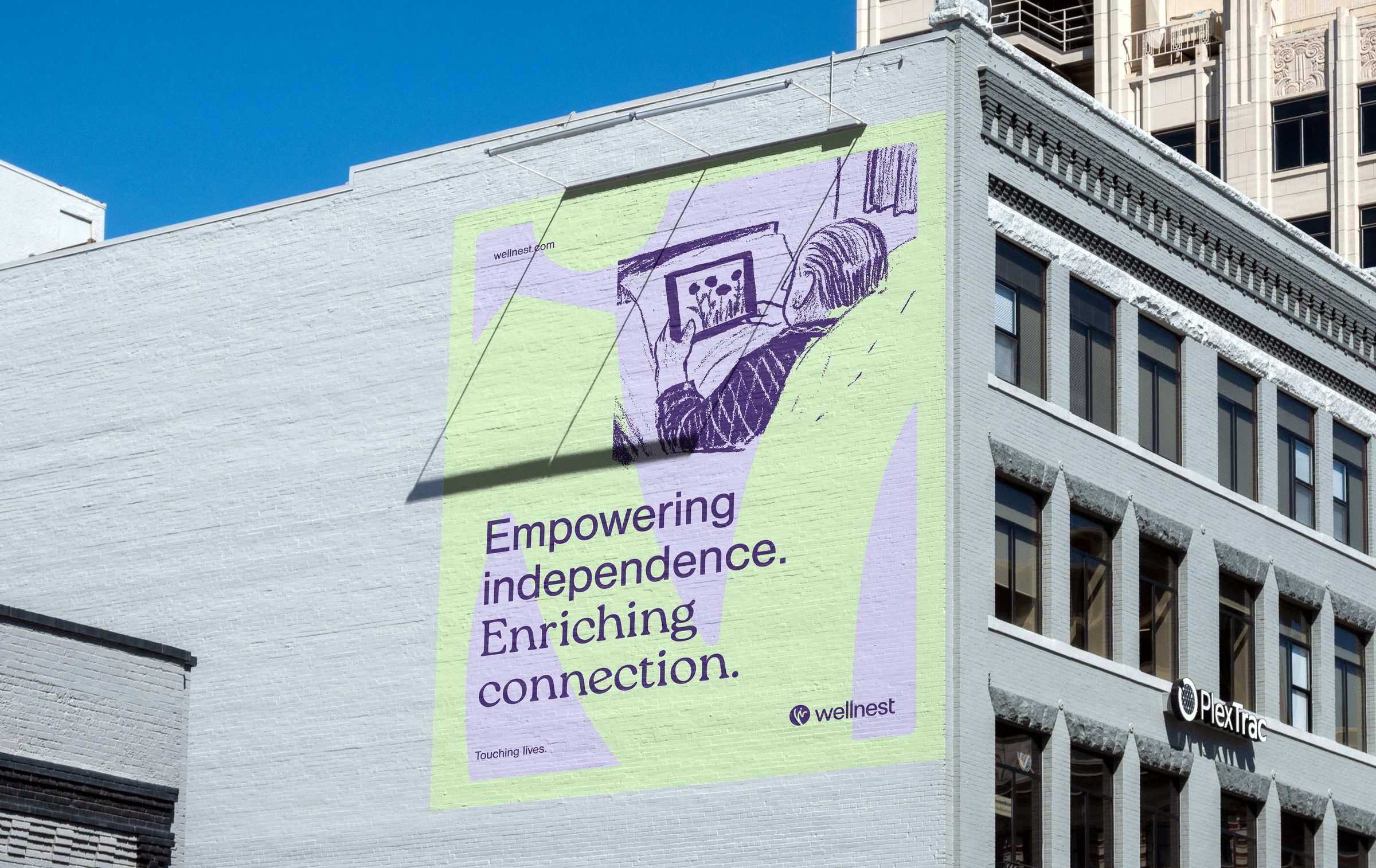 Wellnest 'Empowering independence. Enriching connection.' mural on a downtown brick building