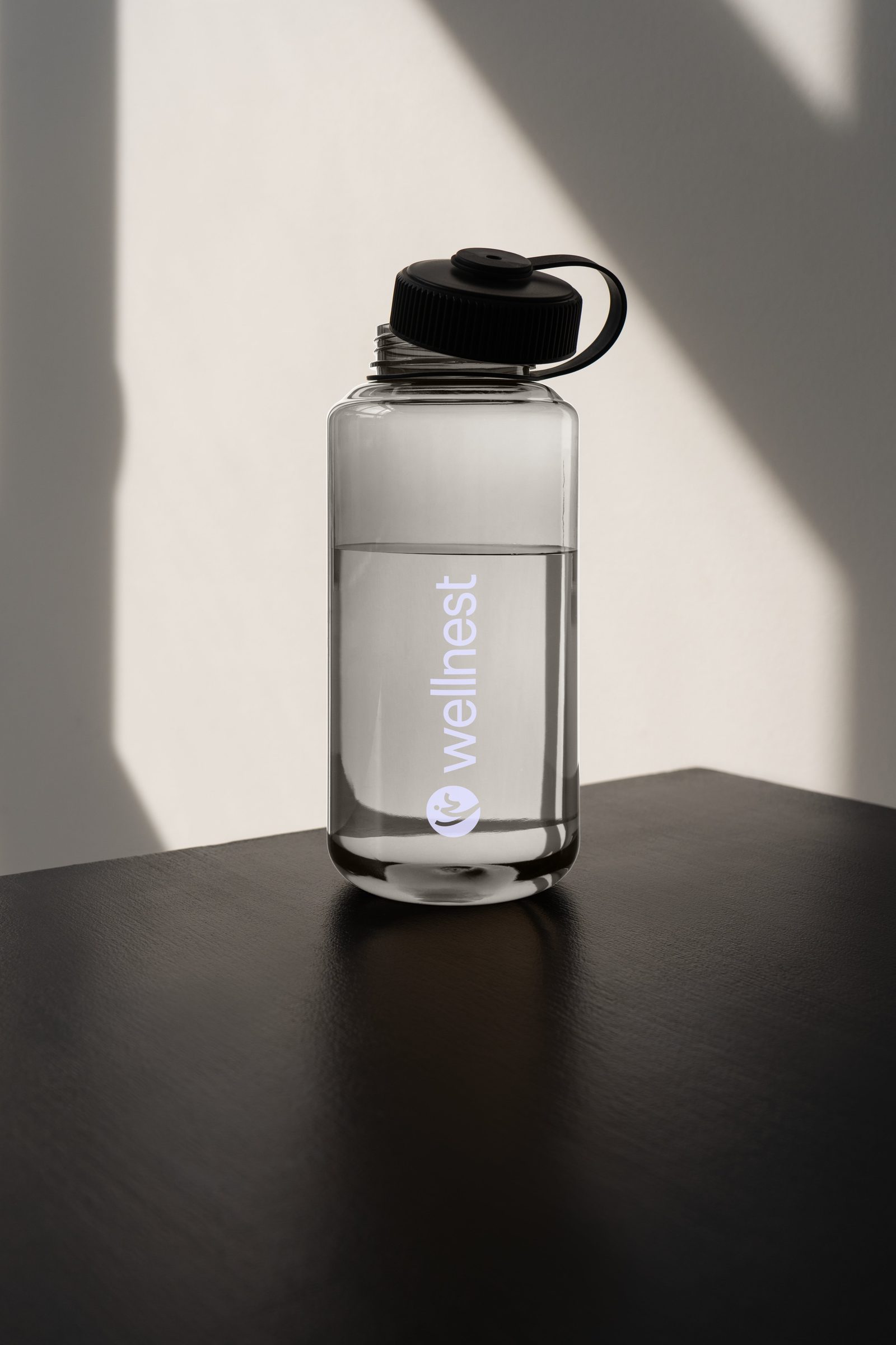 Wellnest branded water bottle in soft directional light